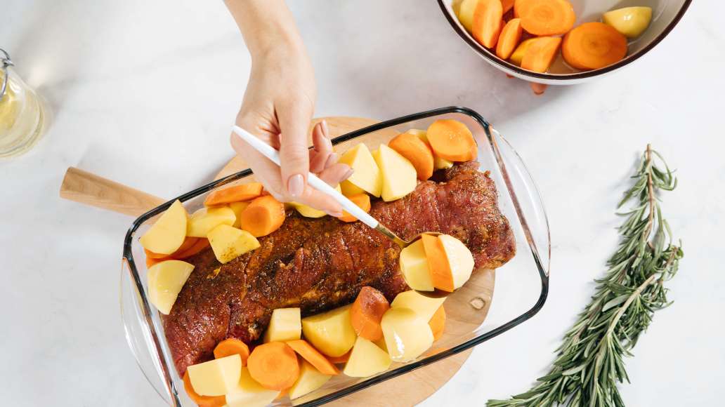 В форму для запекания переложить мясо, вокруг распределить овощи и добавить веточки розмарина сверху. В форму для запекания переложить мясо, вокруг распределить овощи и добавить веточки розмарина сверху.