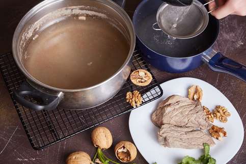 Вынуть мясо и остудить. Бульон процедить через частое сито. Измельчить орехи. Вынуть мясо и остудить. Бульон процедить через частое сито. Измельчить орехи.