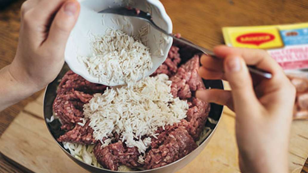 Смешать фарш, овощи и рис, не cливая из риса воду.