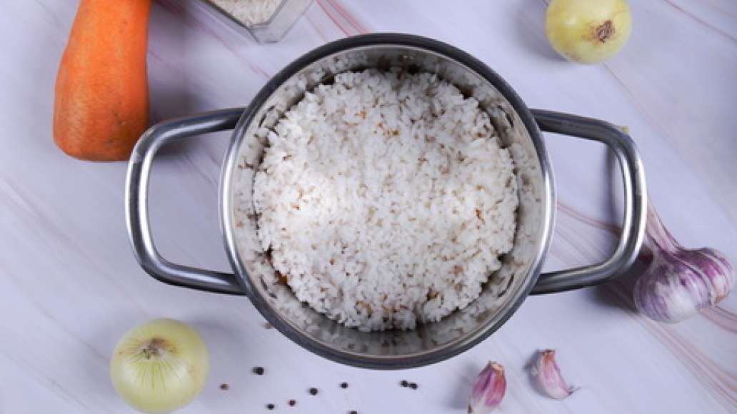 Слейте воду с риса и выложите его поверх мясной зажарки. Слейте воду с риса и выложите его поверх мясной зажарки.