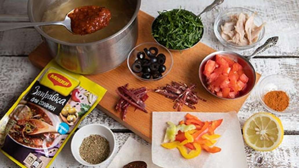 За пять минут до готовности добавить MAGGI® Заправка для солянки, нарезанную зелень, отварную курицу, нарезанные бастурму и суджук, аджику, хмели сунели, копченую паприку. Довести до полной готовности, проверить на соль и довести до нужного вкуса.
