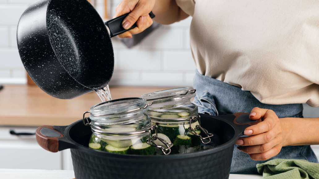 На дно большой кастрюли выложить кухонное полотенце. Поставить в кастрюлю банки с огурцами. Влить горячую воду по «плечики» банок (не использовать кипяток, так как банки могут лопнуть). На дно большой кастрюли выложить кухонное полотенце. Поставить в кастрюлю банки с огурцами. Влить горячую воду по «плечики» банок (не использовать кипяток, так как банки могут лопнуть).