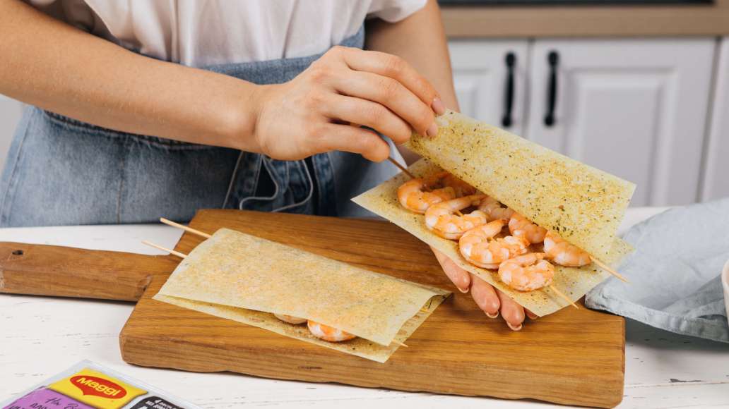 Выложить шпажки с креветками на развернутые листы MAGGI® НА ВТОРОЕ для нежного филе куриной грудки с чесноком и травами. Накрыть второй половиной листов и прижать рукой. Выложить шпажки с креветками на развернутые листы MAGGI® НА ВТОРОЕ для нежного филе куриной грудки с чесноком и травами. Накрыть второй половиной листов и прижать рукой.