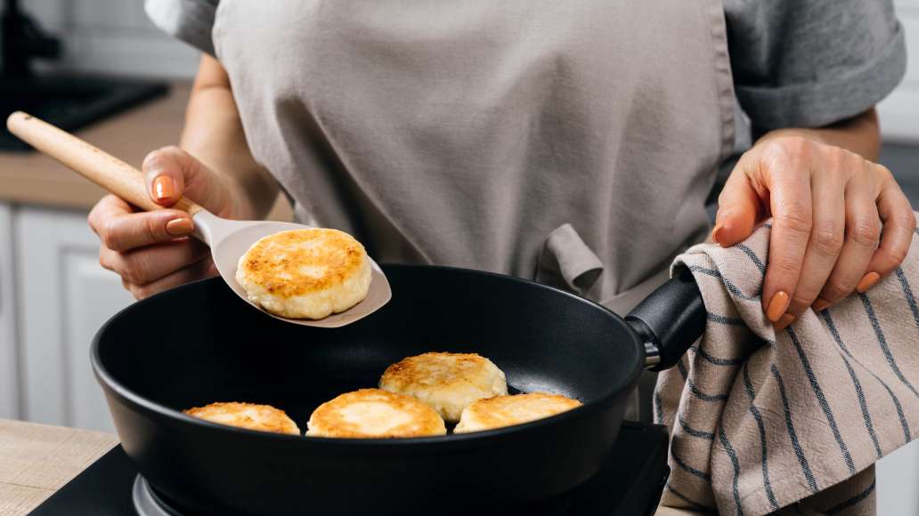 Разогреть сковороду и смазать растительным маслом. Выложить на сковороду сырники и жарить до золотистого цвета с обеих сторон на умеренном огне.
