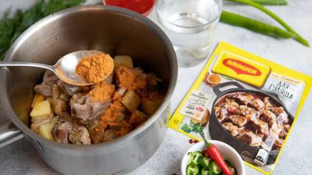 Добавить MAGGI® НА ВТОРОЕ для гуляша, воду, острый перец, нарезанный колечками, помидоры в собственном соку. Тушить до готовности.