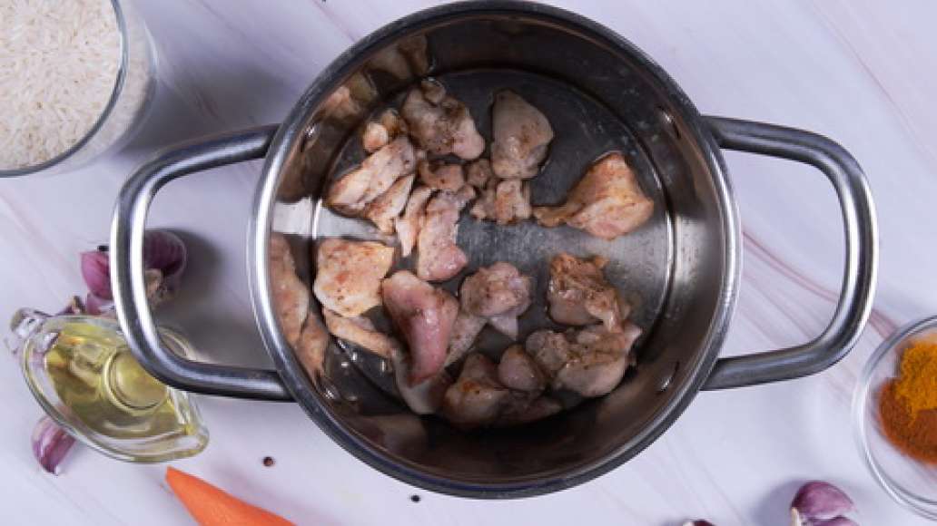 Нарежьте курицу на небольшие кусочки и обжарьте в растительном масле в большой кастрюле.