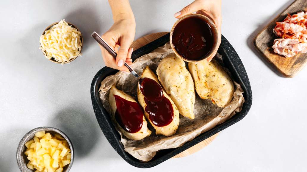 Достать форму с курицей из духовки и полить соусом BBQ (если соус очень густой, разбавить предварительно небольшим количеством воды).
