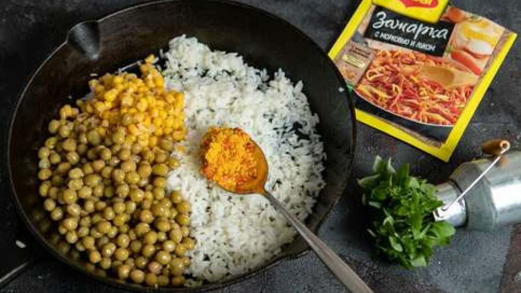 Отварить рис до готовности. Переложить рис  в сковородку, посыпать MAGGI® Зажарка, добавить горошек и кукурузу, тщательно перемешать и прогревать 5 минут.