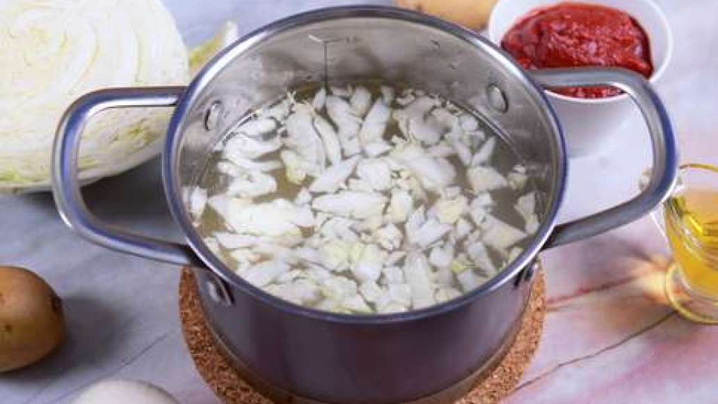 Выньте мясо, морковь и лавровый лист из бульона, процедите его и верните на огонь. Нашинкуйте капусту и поместите в кипящий бульон. Очистите картофель, нарежьте кубиками и добавьте в кастрюлю, варите 15 минут. 