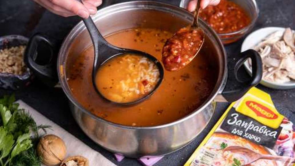 Мелко порубить грецкие орехи. Нарезать мясо небольшими кубиками. Довести бульон до кипения, всыпать рис и варить на среднем огне 10-15 минут. Добавить MAGGI® Заправка для харчо, курицу, нут и орехи и готовить еще 5-7 минут.