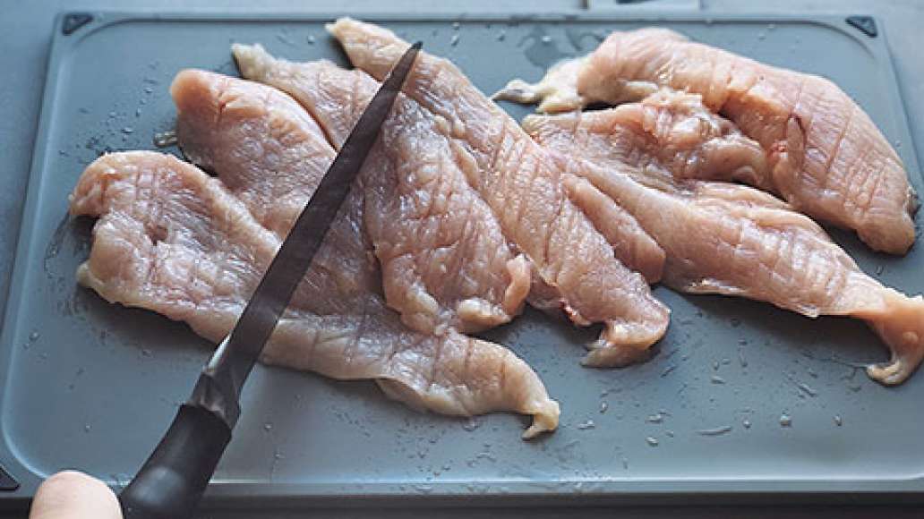 Куриное филе нарезать плоскими кусочками и отбить обратной стороной ножа. посолить.