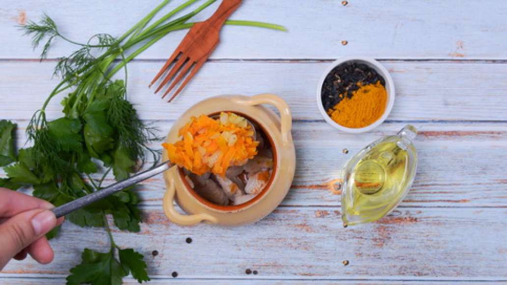 Разложите обжаренное мясо в горшочки, сверху положите слой зажарки. Добавьте приправу и выложите слой риса. Влейте воду так, чтобы она покрывала рис на 1.5-2 см. 
