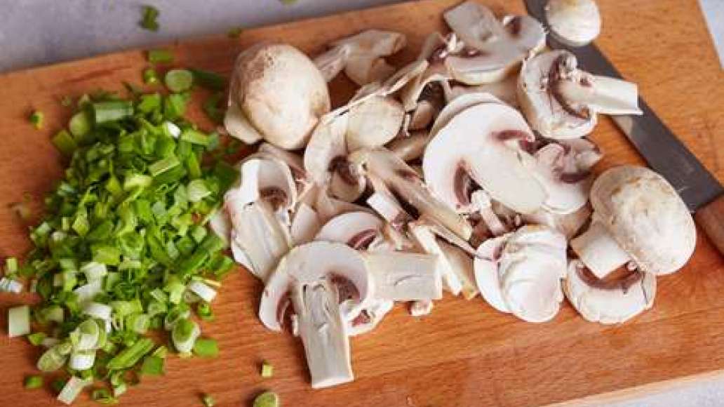 Нарезать шампиньоны кусочками. Разогреть сковородку и раскалить масло.