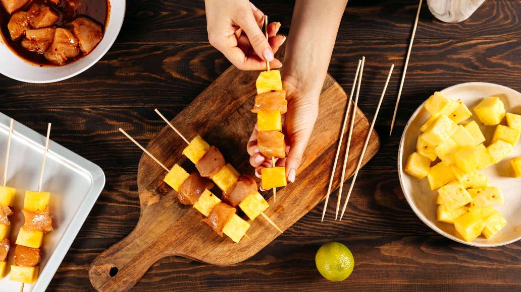 Нанизать на шпажки мясо, чередуя с кусочками ананаса, и выложить на противень. Маринад сохранить.