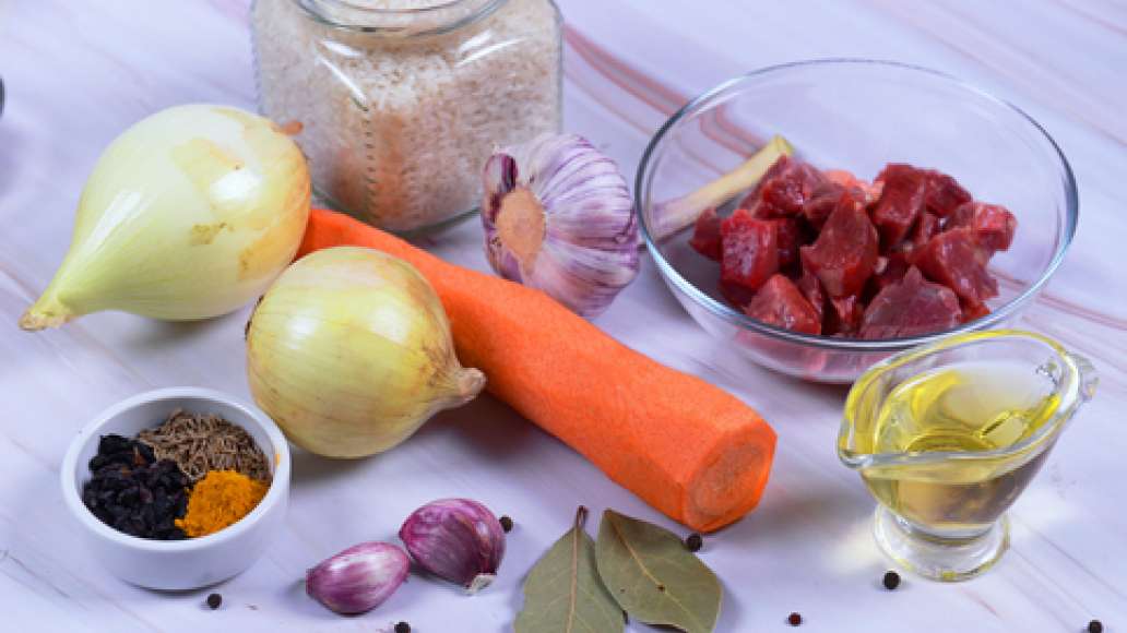 Подготовьте ингредиенты, промойте мясо. Несколько раз промойте рис и залейте холодной водой.