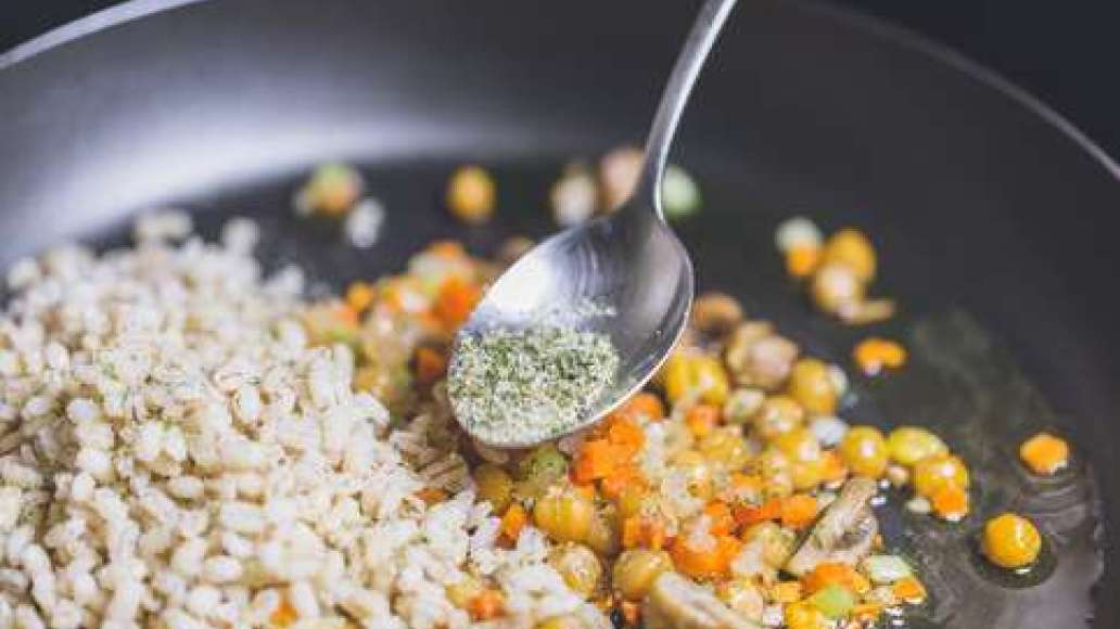 В готовую крупу добавить MAGGI Приправа Весенняя зелень. Соединить в сковородке крупу, обжаренные овощи и грибы, нут и тщательно перемешать. Добавить мелко нарезанную зелень.  Дать специям отдать свой аромат в горячей массе.