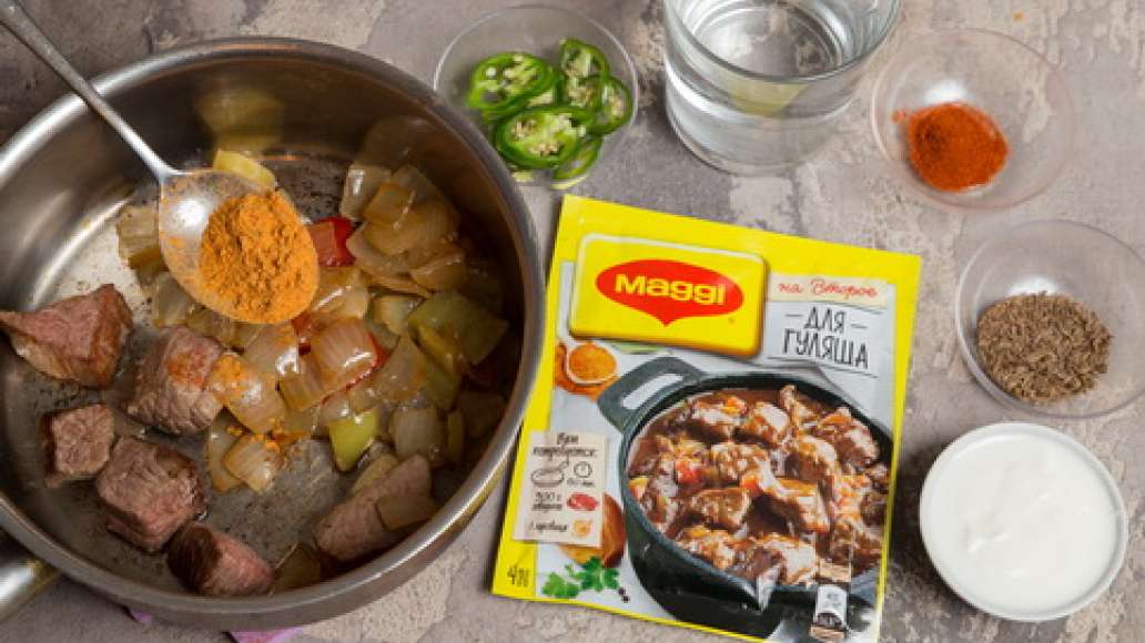 Добавить MAGGI® НА ВТОРОЕ для гуляша, воду, острый перец, нарезанный колечками, помидоры в собственном соку, муку и сметану. Тушить до готовности.