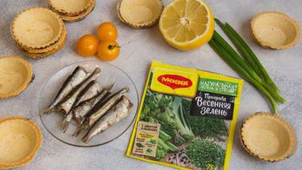 Выжать сок из лимона. Шпроты вынуть из банки и нарезать небольшими кусочками. Помидоры черри разрезать на половинки. 
