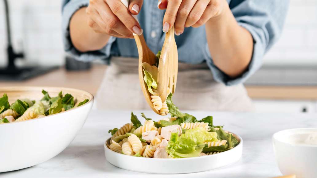 В салатнике смешать пасту, кусочки курицы и салатную зелень. Переложить на блюдо для подачи.
