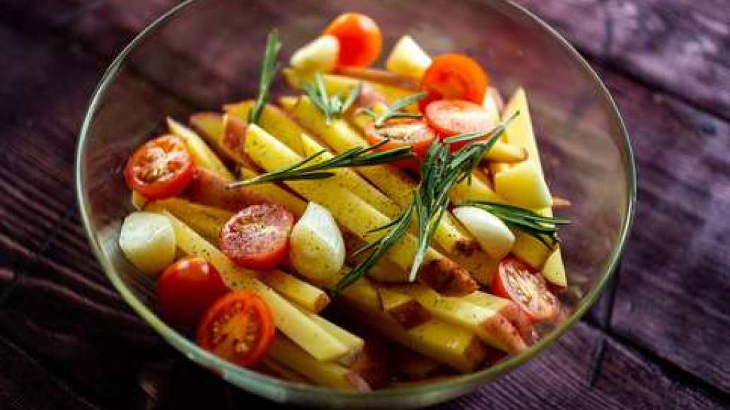 Перемешайте картофель с оливковым маслом, половинками томатов черри, розмарином, чесноком, приправьте солью и перцем. Перемешайте картофель с оливковым маслом, половинками томатов черри, розмарином, чесноком, приправьте солью и перцем.