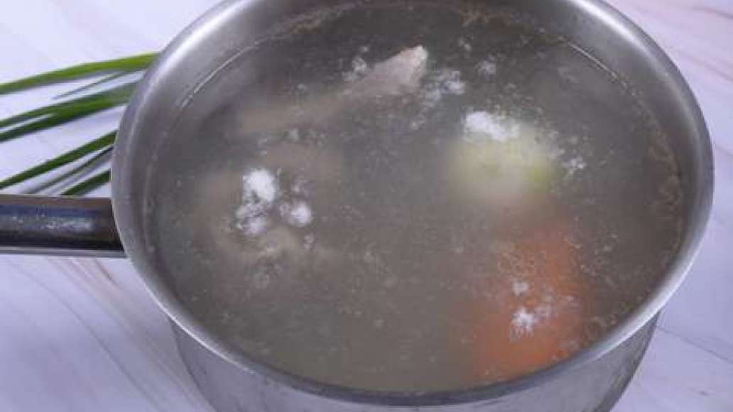 Поместите мясо в кастрюлю, доведите до кипения и снимите пену. Уменьшите огонь и варите 1 час. В это время очистите морковь и лук и затем поместите в кастрюлю. Варите ещё 1,5 часа. 