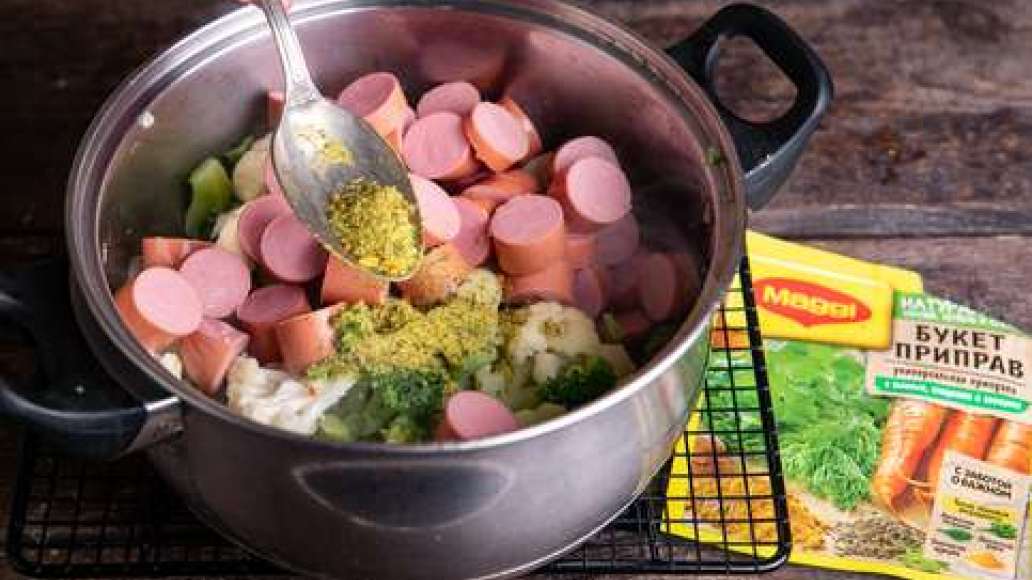 Нарезать картофель кубиками, положить в кастрюлю и отварить, постоянно помешивая, вместе с брокколи и цветной капустой. Чеснок очистить и крупно нарезать. Добавить в кастрюлю сосиски, MAGGI® Приправа универсальная Букет приправ и чеснок. Тушить на среднем