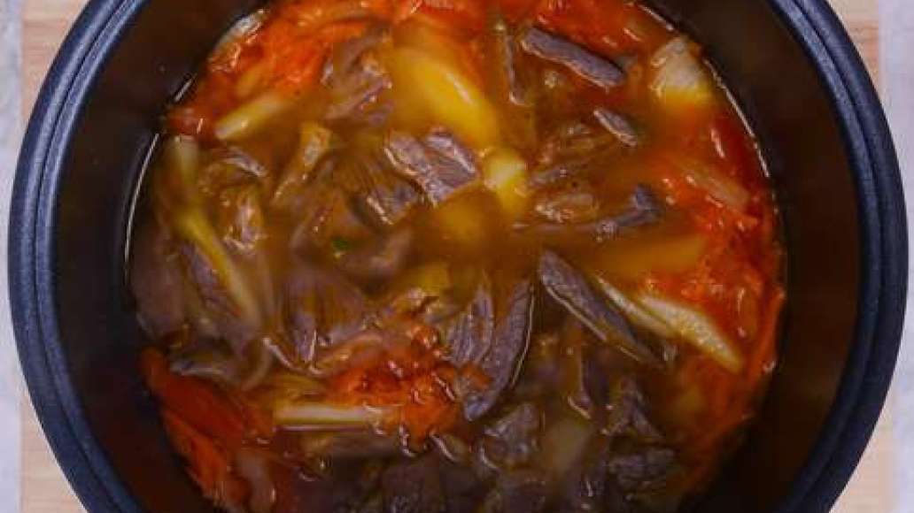 Вареное мясо нарежьте на небольшие кусочки и добавьте к овощам. Вылейте в мультиварку весь бульон из-под мяса. 