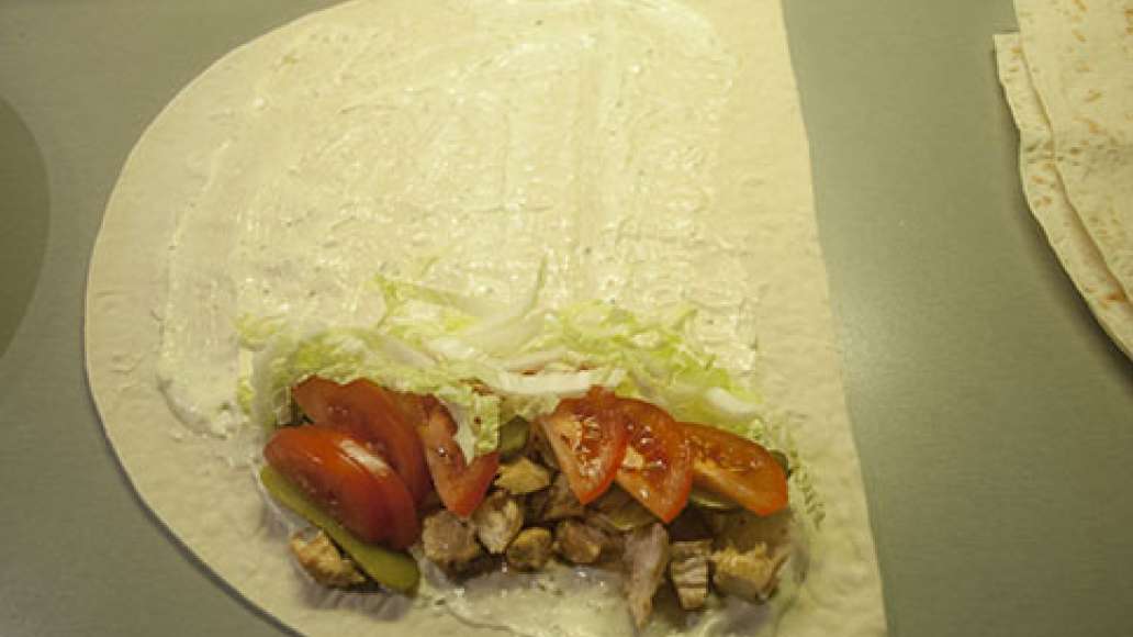 Лаваш смазываем майонезом и выкладываем на край курицу, помидоры, огурец и капусту. Лаваш смазываем майонезом и выкладываем на край курицу, помидоры, огурец и капусту.