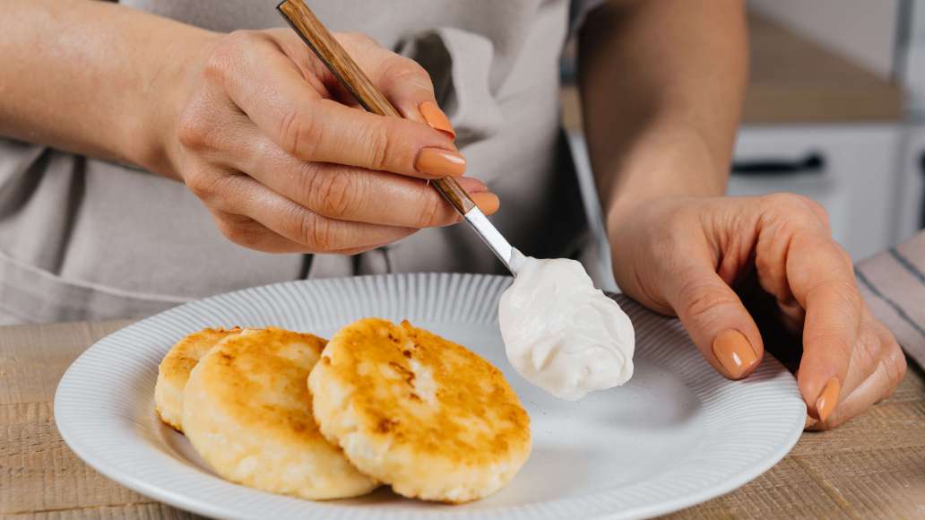 Готовым сырникам дать немного остыть, украсить по своему вкусу и подавать со сметаной.