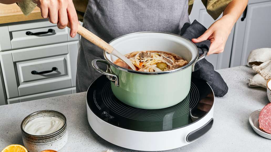 Говяжьи кости и куриное мясо вынуть из бульона и мелко нарезать. Далее в
бульон добавить мясо и тушеные овощи, довести до кипения.