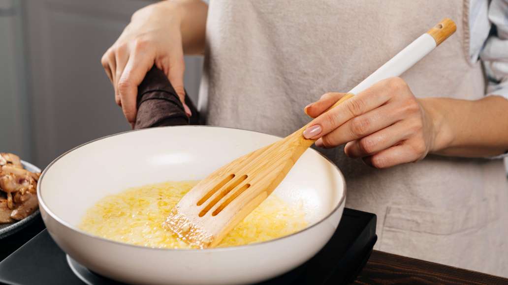 Раскалить в сотейнике растительное масло и порциями обжарить куриное мясо до золотистой корочки на сильном огне. Переложить мясо на блюдо. В том же сотейнике разогреть сливочное масло и обжарить лук до прозрачности на среднем огне.