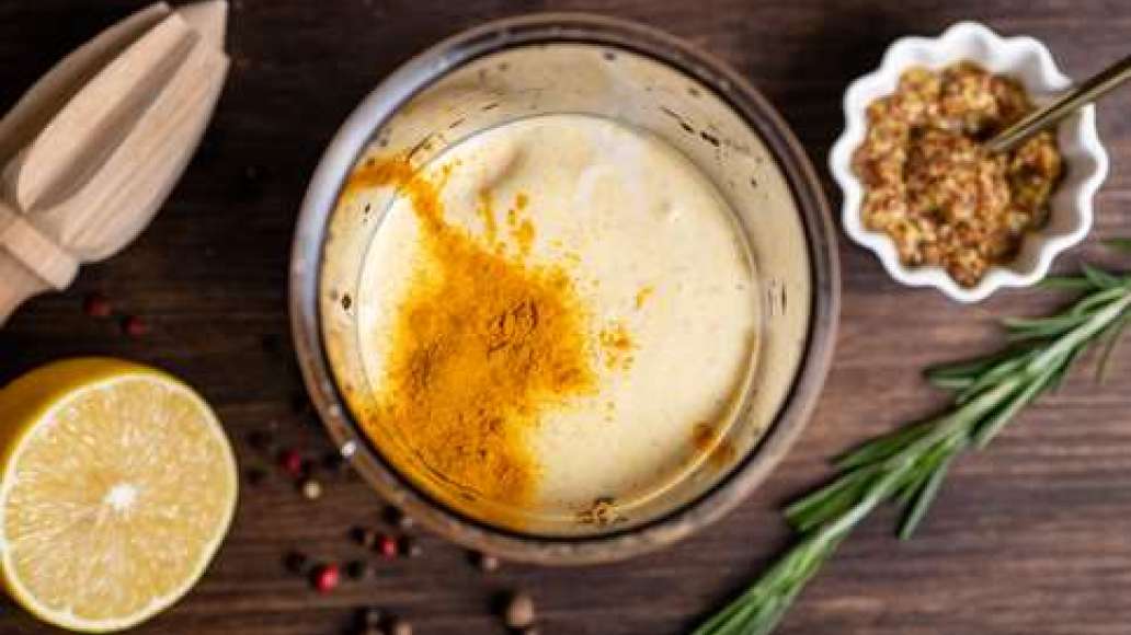 Добавить в массу соевый соус, куркуму, соль, перец, лимонный сок, горчицу, зелень и сахар. Ещё раз взбить до получения гладкого соуса.