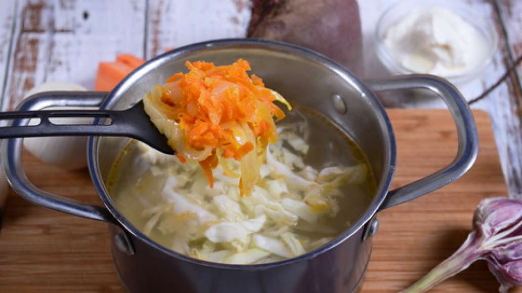 Когда мясо приготовится, выньте его из бульона, слегка охладите. В это время процедите бульон, нашинкуйте капусту, нарежьте картофель соломкой. Поставьте бульон на огонь и добавьте в него картофель и капусту. Снимите кожу с курицы, разрежьте мясо на порци
