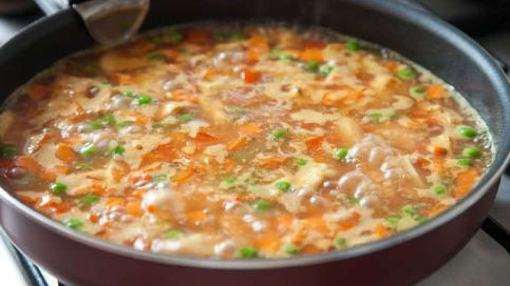 Убавить огонь, накрыть сковороду крышкой и, не перемешивая, варить 15-20 минут, пока рис не впитает всю воду. 