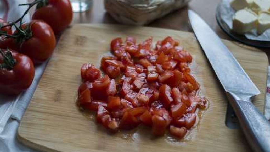 Затем нарежьте томаты небольшими кубиками.