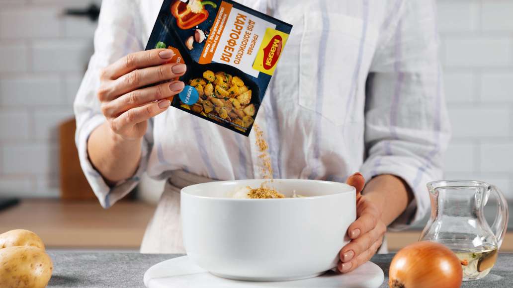 Тщательно отжать лишнюю влагу, используя мелкое сито. Добавить MAGGI® Приправа для золотистого картофеля и тщательно перемешать.