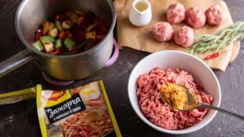 Кабачок нарезать крупными кубиками. Освободить от семян стручок болгарского перца и нарезать крупными кубиками. Соединить фарш с MAGGI® Зажарка и тщательно перемешать. Сформировать небольшие круглые фрикадельки. Выложить овощи в форму или сковородку. Доба