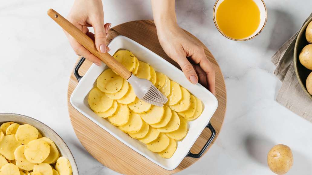 Растопить топлёное масло. Смазать форму для запекания маслом, выложить слой картофеля внахлёст и обильно смазать маслом. Растопить топлёное масло. Смазать форму для запекания маслом, выложить слой картофеля внахлёст и обильно смазать маслом.