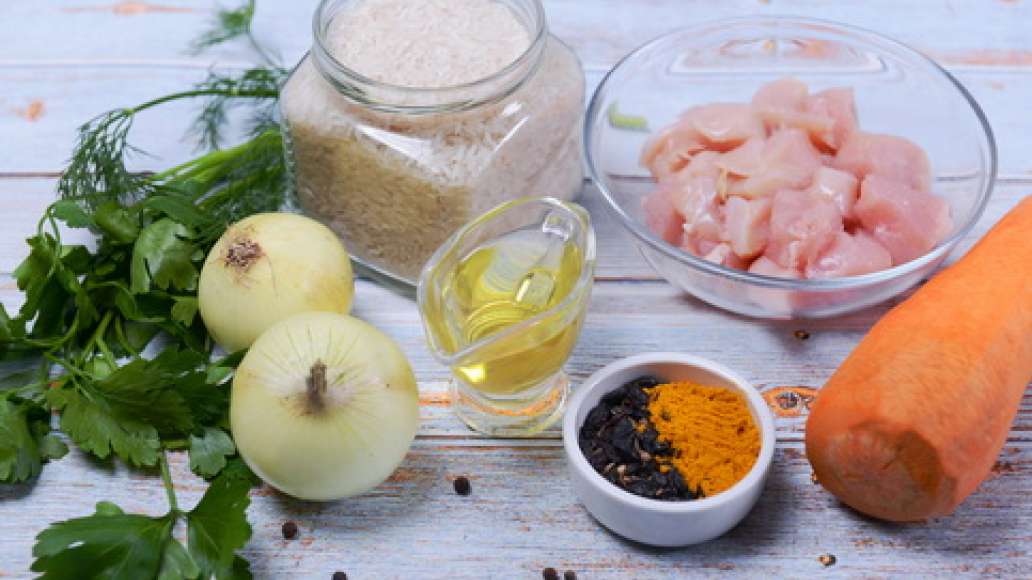 Подготовьте ингредиенты, промойте курицу и нарежьте на порционные кусочки. Промойте рис и замочите в холодной воде на то время, пока готовятся другие ингредиенты.  