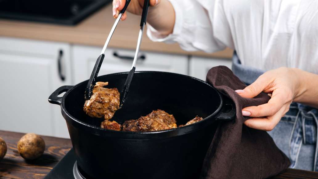 Раскалить курдючное сало в казане. Погрузить мясо в жир и обжарить до румяной корочки со всех сторон на сильном огне. Убавить огонь до слабого, накрыть крышкой и томить в течение 10-15 минут.