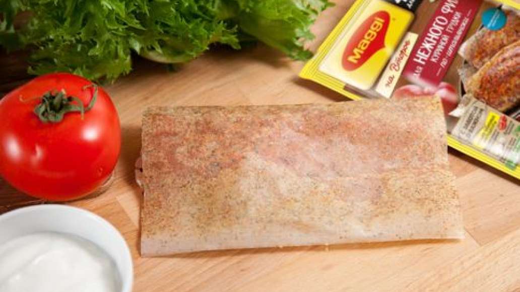 Накрыть куриную грудку второй половиной листа. Завернутую грудку прижать рукой.
