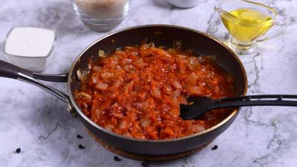 Натрите морковь на крупной терке, нарежьте лук кубиками. Обжарьте на растительном масле, добавьте томатную пасту, воду и соль.