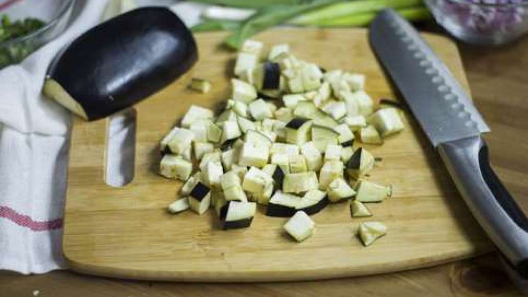 Нарежьте баклажан средними кубиками.