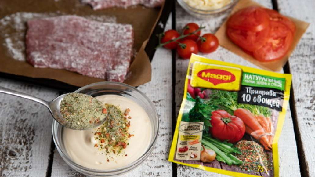 Антрекоты из говядины отбить кухонным молотком. Застелить противень пергаментной бумагой или смазать при помощи кулинарной кисти растительным маслом. Мясо запанировать в муке и стряхнуть излишки. Разложить антрекоты на противне, сверху выложить помидоры. 