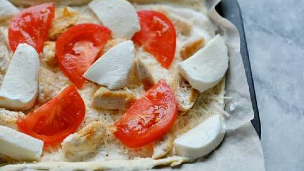 Выложить на тесто готовое мясо, помидор, порезанный дольками, и моцареллу. Отправить в духовку на 25 минут.