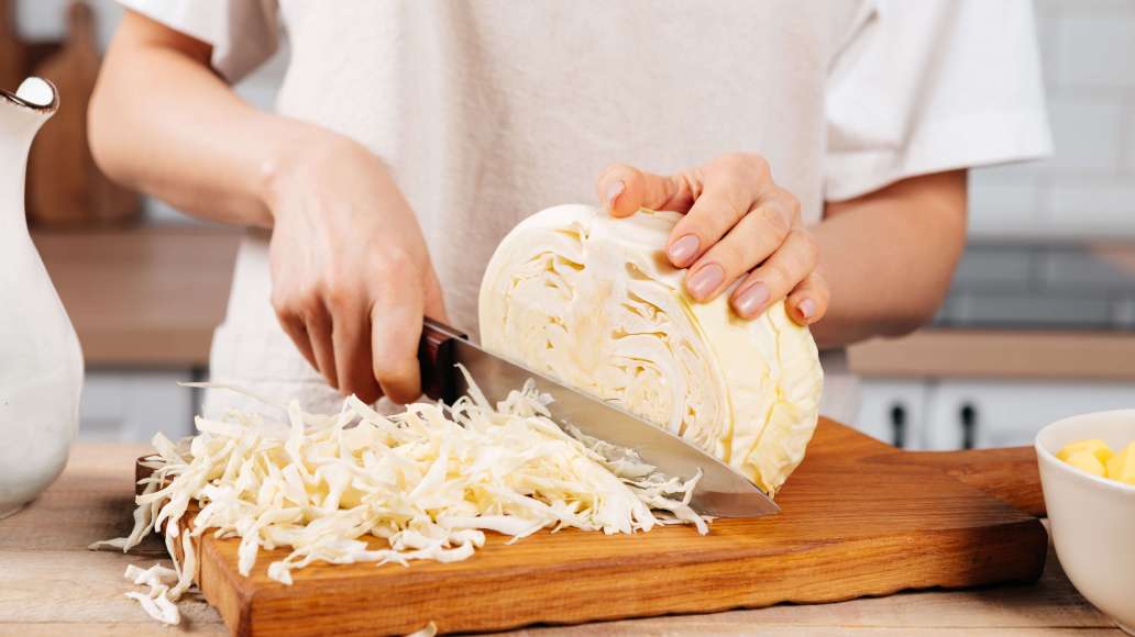 Готовое мясо вынуть из бульона. Очищенный картофель нарезать кубиками среднего размера. Капусту тонко нашинковать. Добавить в бульон и варить 10-15 минут.