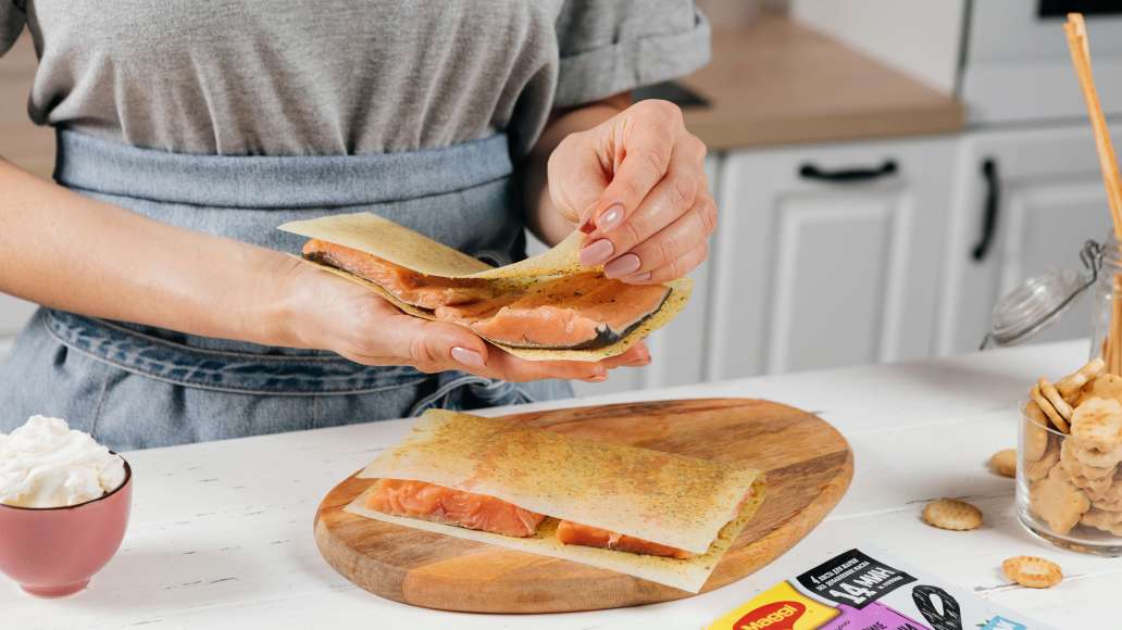 Уложить рыбу на раскрытые листы MAGGI® НА ВТОРОЕ для нежного филе куриной грудки с чесноком и травами. Накрыть сверху свободными половинками листов. Уложить рыбу на раскрытые листы MAGGI® НА ВТОРОЕ для нежного филе куриной грудки с чесноком и травами. Накрыть сверху свободными половинками листов.