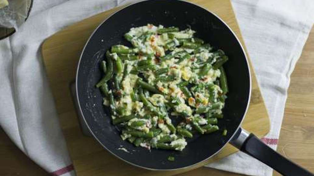 Затем разбейте в сковороду куриные яйца. Жарьте, постоянно помешивая, до готовности.