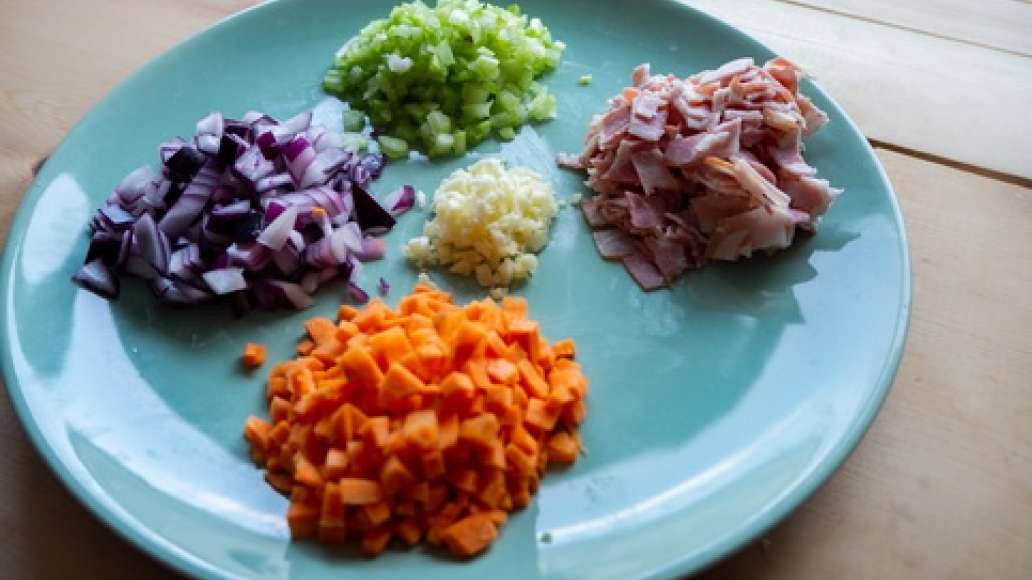 Нарежьте лук, чеснок и морковь мелкими кубиками. Очистите и мелко порубите сельдерей и листья розмарина. Нарежьте бекон на тонкие полоски.
