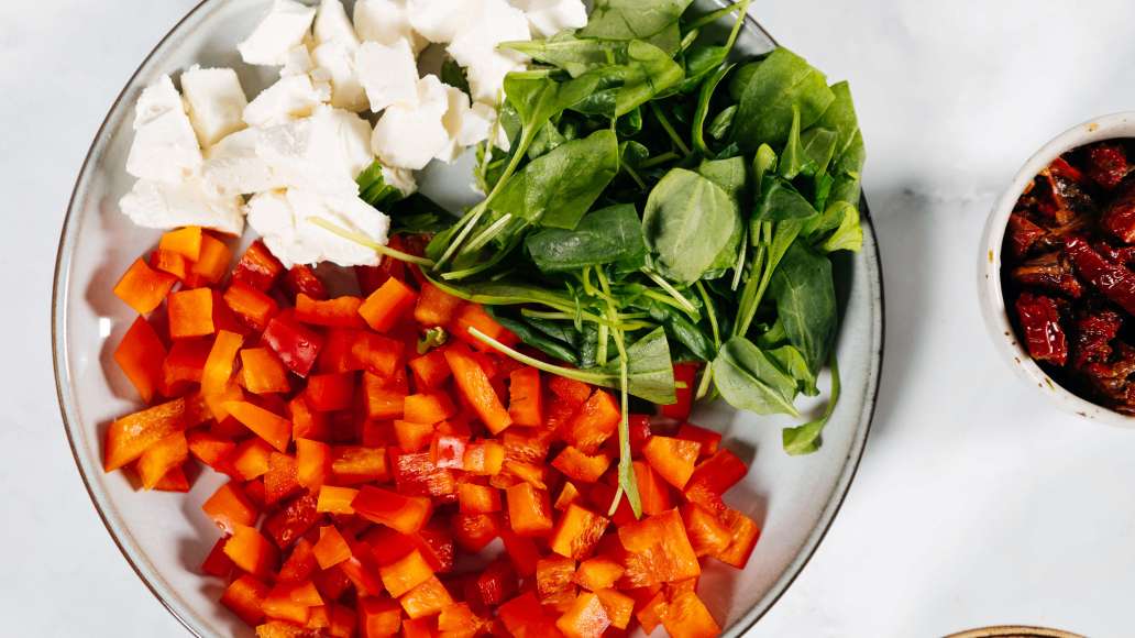 Нарезать сладкий перец кубиками, крупно порезать листья шпината, раскрошить фету.
